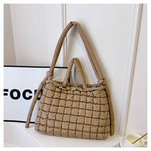 Close-up of khaki quilted puffer tote bag with knot detail and minimalist aesthetic