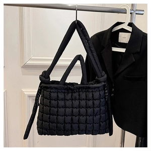 Détail du sac cabas matelassé noir avec nœud décoratif et bandoulière rembourrée