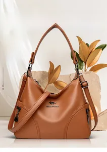 Detail view of brown pebbled leather tote bag with gold kangaroo logo and adjustable strap