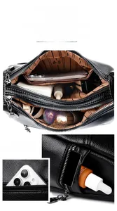 Detail view of black lychee leather bag with multiple zip compartments and spacious interior