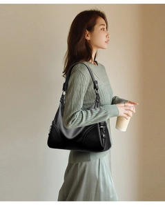 Detailed view of black hobo bag with pebble leather texture on a female model