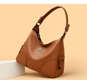 Close-up of brown lychee grain leather handbag with logo and metal zipper detail