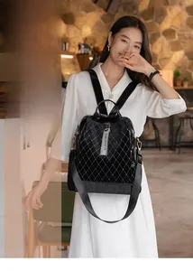 Detail of black quilted faux leather backpack featuring silver hardware and rivets