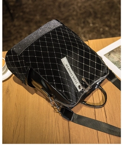 Detail of black glossy backpack with silver rhinestones and quilted diamond patterns