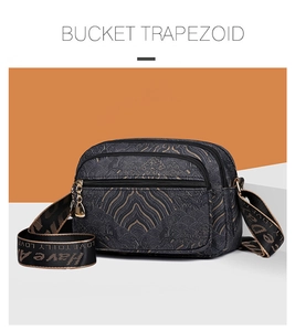 Detail of multi-pocket crossbody bag with vintage pattern and triple zipper compartments