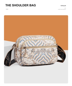 Detail of vintage jacquard pattern and multiple zipper compartments on the shoulder bag