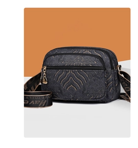 Detail view of vintage navy jacquard bag with multiple gold zippers and wide strap