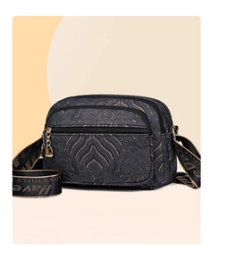 Macro detail of multi-pocket nylon bag with gold wave pattern and Love To Fly strap