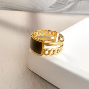 Macro view of gold-plated chain-link ring with a rectangular black enamel inlay design