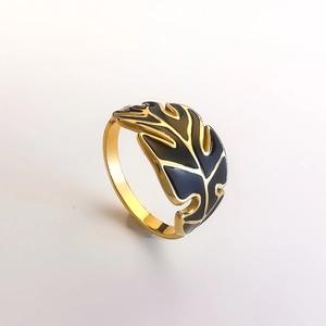Detailed view of golden leaf ring with black enamel inlay and hollowed design