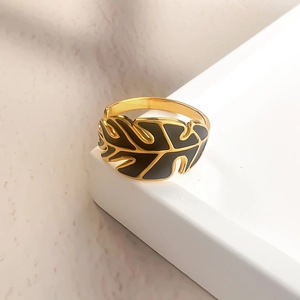 Minimalist gold palm leaf open ring with black enamel details and polished metal finish