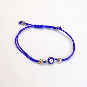 Detail view of the handmade blue woven Evil Eye bracelet with adjustable gold beads