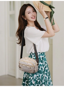 Detail of vintage patterned multi-pocket crossbody bag with woven jacquard texture and strap