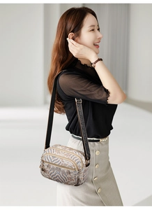 Side view of multi-pocket crossbody bag with vintage khaki print on fashion model