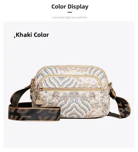 Detail of khaki crossbody bag featuring three zipper pockets and vintage woven patterns