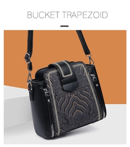 Detail view of the trapezoid bucket bag with jacquard texture and golden chain stitching