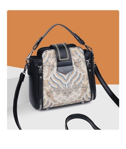 Detail of Chinese style embroidery featuring golden waves on a black leather crossbody bag