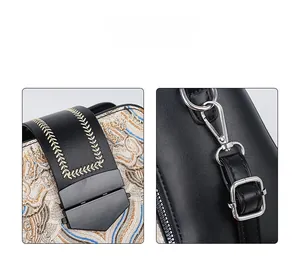Detail showing the floral embroidery pattern and metallic silver lock on black leather bag