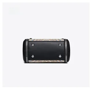 Detail of cylindrical bag bottom with four silver metal studs and vintage printed fabric