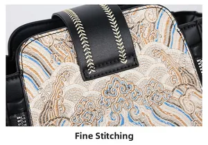 Detail of national style embroidery patterns and fine stitching on a black leather bag