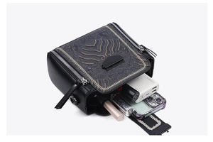Detail view of black crossbody bag showing spacious interior with multiple compartments