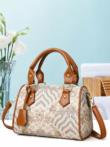 Macro view of textured embroidery and brown leather trim on the large shoulder bag