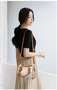 Detailed close-up of a high-quality wave pattern fabric handbag with brown leather handles