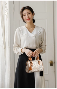 Detail of large capacity shoulder bag with traditional wave pattern and leather trim
