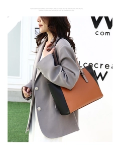 Bolso tote bicolor marrón y negro en modelo con correa de hombro y hebilla metálica