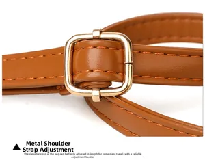 Detail view of the brown leather shoulder strap with adjustable gold metal buckle