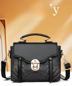 Detail of elegant black shoulder bag with gold textured panels and metallic buckle