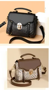 Detail view of vintage print handbags in black and brown patterns with gold metal buckles