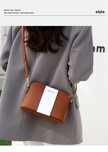 Borsa tote bicolore marrone e bianca con dettagli dorati indossata da una modella