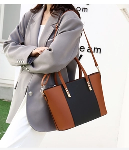 Borsa tote bicolore marrone e nera con tracolla abbinata a un completo da ufficio