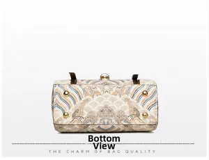 Detail view of handbag bottom featuring wave patterns and four gold metal protective studs