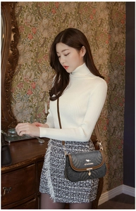 Close-up of retro embossed grey shoulder bag with gold kangaroo logo and chain strap