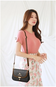 Close-up of ethnic crossbody bag featuring wave embroidery and golden leaf pendant