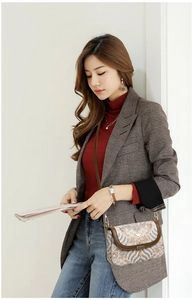 Detail of retro wave pattern crossbody bag with brown leather trim and gold metal lock