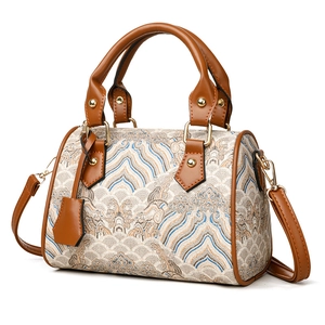 Boston style tote bag with mountain embroidery and brown leather handles on white background