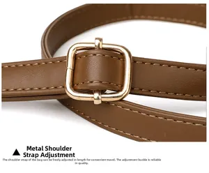 Detail of adjustable brown leather shoulder strap with durable gold hardware buckle