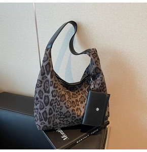 Detail der Leopard-Tasche mit schwarzem Lederriemen und kleiner Münztasche zum Einhängen