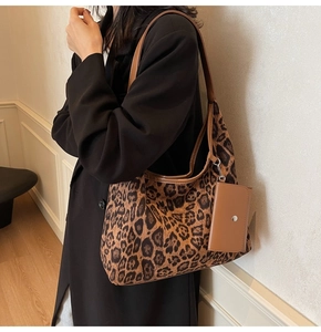 Detail of leopard print tote bag with brown leather pouch and textured handles