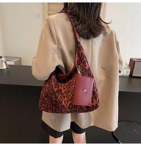 Detail of leopard print tote bag with functional red leather card pouch attachment