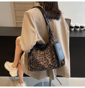 Detailed side view of leopard print tote bag with a small black pouch on model
