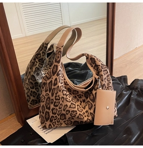 Close-up of leopard print tote bag texture with solid handle and beige small pouch