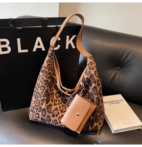 Dettaglio della borsa tote leopardata con tracolla in pelle marrone su divano