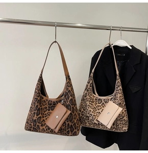 Dettaglio borsa shopper leopardata con pochette coordinata su un appendino metallico