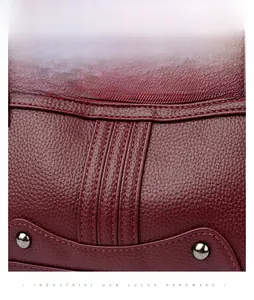 Détail du cuir texturé bordeaux avec quincaillerie de couleur fusil sur sac pour femme