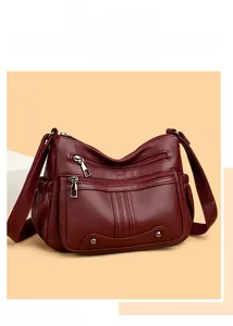 Détails du sac à main bordeaux en cuir grainé avec trois poches zippées et clous