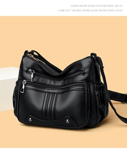 Détail du sac à main noir en cuir grainé avec plusieurs poches zippées métalliques